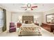 Bedroom with upholstered headboard bed, ceiling fan, large windows, and dark wood furniture at 1386 Sheffield Glen Ne Way, Atlanta, GA 30329