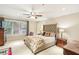 Bright main bedroom featuring a tufted headboard, floral bedding, ceiling fan and large window at 1386 Sheffield Glen Ne Way, Atlanta, GA 30329