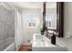 Bathroom featuring a tub with marble tile surround, and a single vanity with modern fixtures at 2148 Allgood Rd, Marietta, GA 30062