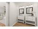 Bright bathroom featuring double sinks with white cabinets, modern fixtures, and wood flooring at 2148 Allgood Rd, Marietta, GA 30062