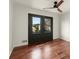 Bedroom featuring black french doors that overlook the exterior of the home with hardwood floors and ceiling fan at 2148 Allgood Rd, Marietta, GA 30062