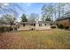 Backyard view featuring a white brick house, chimney, and a spacious grassy area at 2151 Zelda Ne Dr, Atlanta, GA 30345