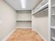 Walk-in closet boasting custom shelving and terra cotta tile flooring at 2151 Zelda Ne Dr, Atlanta, GA 30345