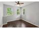 Bright bedroom featuring hardwood floors, a ceiling fan, and natural lighting from three windows at 101 Swanton Hill Ct, Decatur, GA 30030