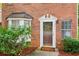 Close-up of brick exterior and front door with sidelight windows and manicured landscaping at 101 Swanton Hill Ct, Decatur, GA 30030