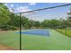 A green and blue tennis court is protected by a chain link fence and surrounded by trees at 101 Swanton Hill Ct, Decatur, GA 30030