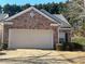 Charming brick home featuring a two-car garage and a patterned paver driveway at 1360 Raven Rock Nw Trl, Kennesaw, GA 30152