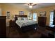 Spacious main bedroom with a ceiling fan, large bed, decorative pillows, dresser, and dark wood flooring at 1360 Raven Rock Nw Trl, Kennesaw, GA 30152