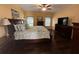 Spacious main bedroom with a ceiling fan, large bed, decorative pillows, dresser, and dark wood flooring at 1360 Raven Rock Nw Trl, Kennesaw, GA 30152