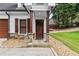 Close-up of a home's front porch with beautiful stonework, wood door, and matching columns at 150 South St, Buford, GA 30518