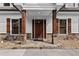 Inviting front porch with decorative stone accents, wood columns, and attractive wood door at 150 South St, Buford, GA 30518