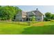 Large fenced backyard with vibrant green grass, partial shade trees, and an inviting outdoor space at 815 Spring View Ct, Covington, GA 30014