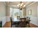 Dining area highlighting classic moldings, a decorative chandelier, and a large window at 815 Spring View Ct, Covington, GA 30014