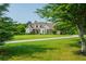 A long driveway to a beautiful brick home with a manicured lawn and mature shade trees at 815 Spring View Ct, Covington, GA 30014