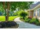 Landscaped walkway featuring brick edging, lush plantings, and a glimpse of the expansive lawn at 815 Spring View Ct, Covington, GA 30014