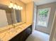 Bright bathroom featuring a marble countertop vanity, a large mirror, and a window view at 225 Kentshire Pl, Lawrenceville, GA 30044