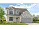 Inviting two-story home featuring a covered porch, neutral siding, brick accents, and a two-car garage at 4171 Brindle Pl, Loganville, GA 30052