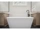 Modern bathroom featuring a soaking tub, dual vanities, and stylish black tile at 591 Brashy St, Woodstock, GA 30188