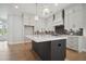 Elegant kitchen with a central island, white cabinetry, and high-end finishes at 591 Brashy St, Woodstock, GA 30188