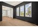 Elegant living room featuring dark wood paneling, large windows, and views of the neighborhood at 591 Brashy St, Woodstock, GA 30188