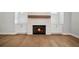 Cozy living room with a stone fireplace, hardwood floors, and built-in cabinets at 591 Brashy St, Woodstock, GA 30188