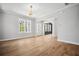 Bright and open living room with large windows, elegant lighting fixtures, and light hardwood floors at 591 Brashy St, Woodstock, GA 30188