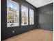 Stylish living room with dark wood paneling, large windows, and light hardwood floors at 591 Brashy St, Woodstock, GA 30188