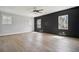 Living room with hardwood floors and a black accent wall with two windows at 591 Brashy St, Woodstock, GA 30188