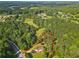 Expansive aerial view of a wooded property featuring a house and a meandering roadway at 75 Auburn Rd, Auburn, GA 30011
