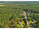 Aerial view showcases a property with surrounding trees, a house, lawn, and neighborhood at 75 Auburn Rd, Auburn, GA 30011