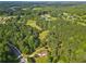 Aerial view of wooded property featuring a house surrounded by lush greenery and a nearby road at 75 Auburn Rd, Auburn, GA 30011