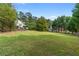 Large grassy backyard with mature trees and partial fencing at 75 Auburn Rd, Auburn, GA 30011
