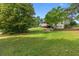Lush backyard featuring a well-maintained lawn, mature trees, patio, and a charming covered deck at 75 Auburn Rd, Auburn, GA 30011