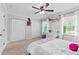 Bright bedroom with a ceiling fan, white trim, and double closets, creating an open and airy feel at 75 Auburn Rd, Auburn, GA 30011