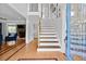Open foyer with hardwood floors, staircase, and a glimpse into the living room featuring a fireplace at 75 Auburn Rd, Auburn, GA 30011