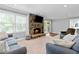 Inviting living room featuring a stone fireplace and views of the backyard at 75 Auburn Rd, Auburn, GA 30011