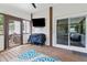 Outdoor sunroom with a grill, TV, and screened windows for outdoor entertainment and gatherings at 75 Auburn Rd, Auburn, GA 30011