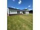 Well-maintained backyard features manicured lawn, covered patio, and exterior stone accents on the house at 861 Pineberry Ct, Grayson, GA 30017