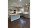 Bright kitchen boasts a large island, stainless steel appliances, gray cabinets, and hardwood floors at 861 Pineberry Ct, Grayson, GA 30017