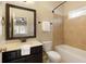 Well-lit bathroom featuring neutral-toned tiling, dark wood vanity, and a combined tub and shower at 1365 Hawthorne Se Ave, Smyrna, GA 30080
