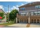 Modern townhouse with multi-car garage, upper-level deck, and a well-manicured lawn under a bright blue sky at 1365 Hawthorne Se Ave, Smyrna, GA 30080