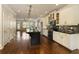 Open-concept kitchen featuring a dark island, white cabinets, stainless steel appliances, and dark hardwood flooring at 1365 Hawthorne Se Ave, Smyrna, GA 30080