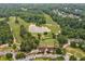 Aerial view featuring a golf course and clubhouse surrounded by lush greenery and trees at 3543 Pine Grove Dr, Douglasville, GA 30135