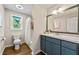 Charming bathroom features a shower and bathtub combination, a blue vanity and a large mirror at 385 Russell Ridge Dr, Lawrenceville, GA 30043
