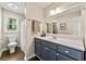 Charming bathroom features a shower and bathtub combination, a blue vanity and a large mirror at 385 Russell Ridge Dr, Lawrenceville, GA 30043