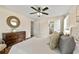 Bright bedroom with a large bed, wood floors, dresser, and ensuite bath with a round decorative mirror at 385 Russell Ridge Dr, Lawrenceville, GA 30043