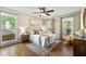 Bright bedroom with large windows and wood floors, complemented by a ceiling fan and stylish decor at 385 Russell Ridge Dr, Lawrenceville, GA 30043