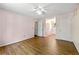 Bright bedroom with light pink walls, wood floors, ceiling fan, and ensuite entry at 385 Russell Ridge Dr, Lawrenceville, GA 30043