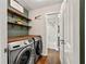 Convenient laundry room with modern washer and dryer, wood countertop, and open shelving at 385 Russell Ridge Dr, Lawrenceville, GA 30043