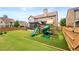 Fenced backyard featuring a covered patio, playground, and well-maintained lawn at 4015 Roberts Crest Ln, Suwanee, GA 30024
